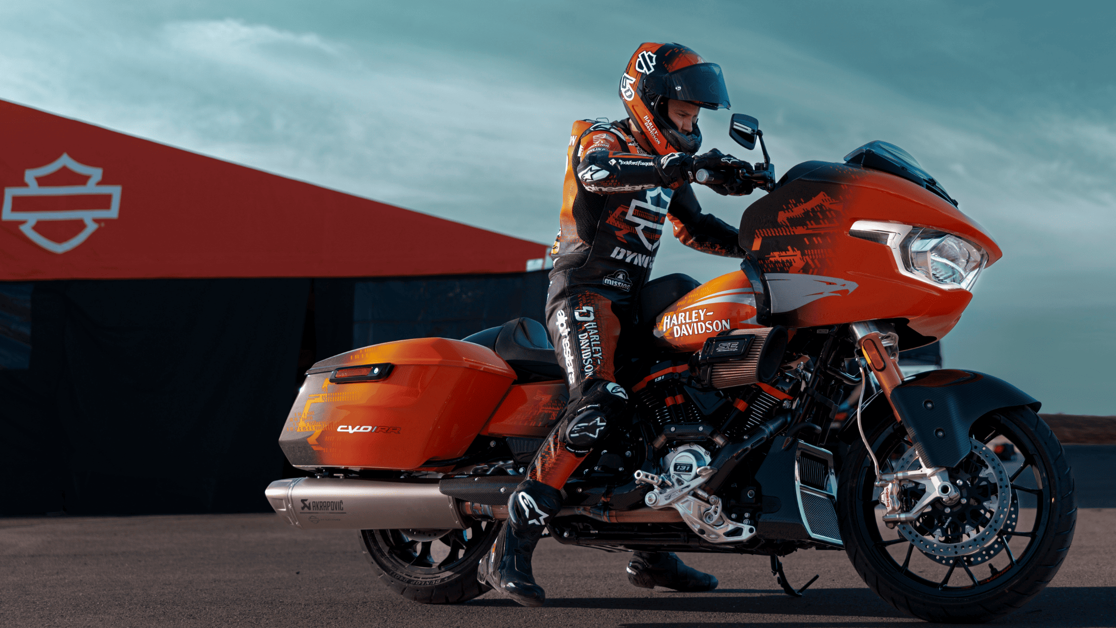 The 2025 Harley-Davidson CVO Road Glide RR in striking orange and black, featuring a performance bagger design, aerodynamic fairing, and premium components.